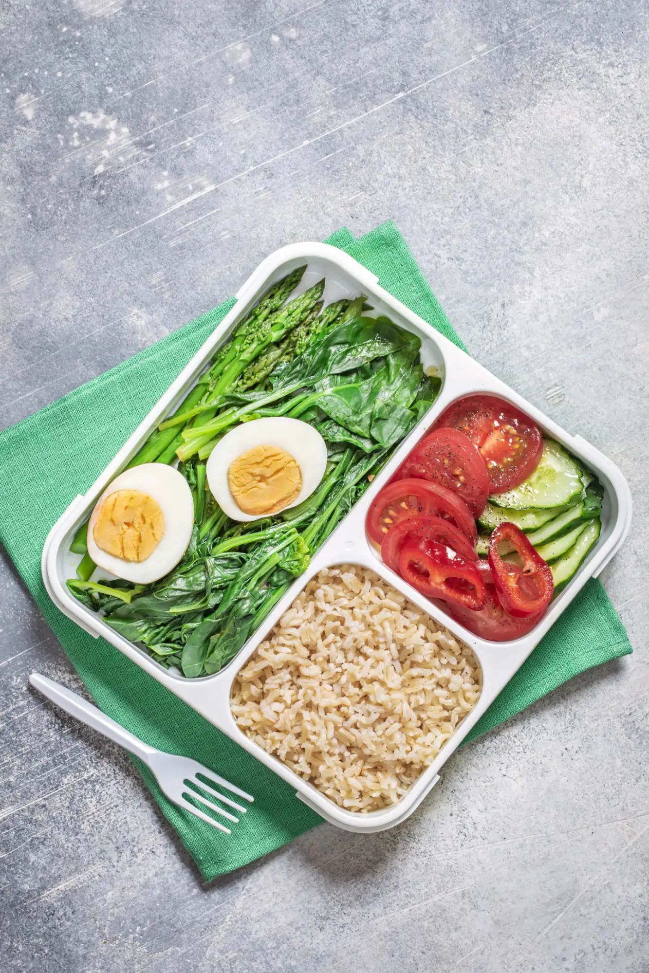 Lunch box składający się z kaszy kuskus oraz warzyw jako inspiracja na szybki posiłek do pracy.